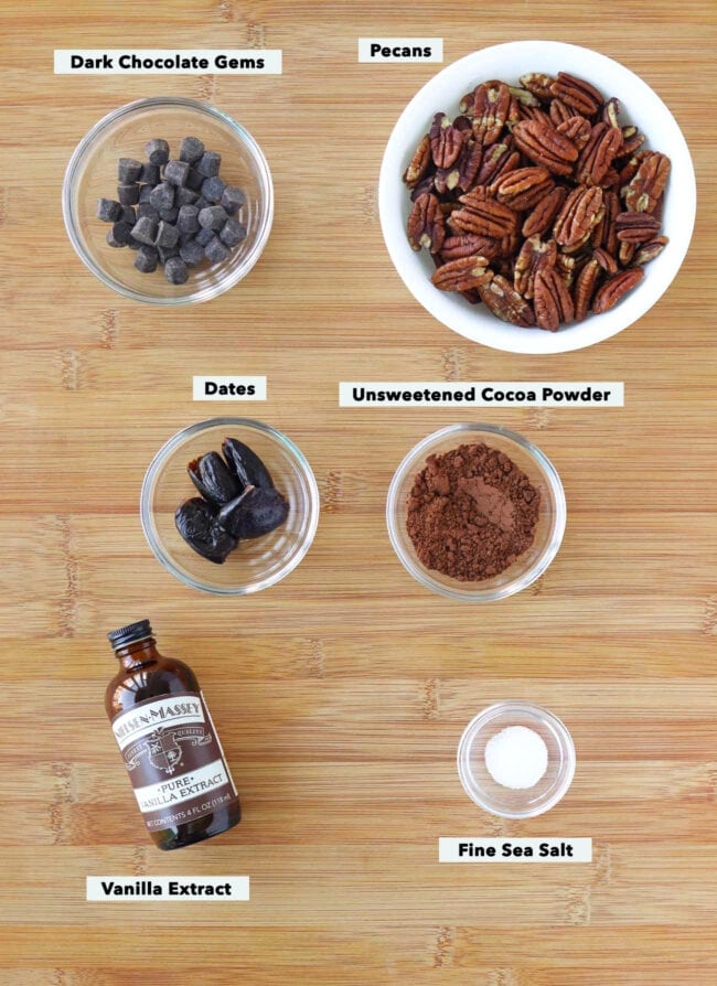 Labeled ingredients for dark chocolate pecan butter on a wood board.