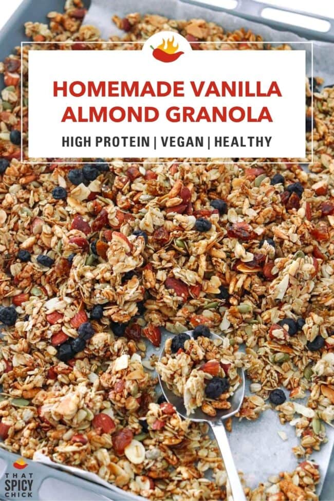 Vanilla almond granola on a baking tray with a spoon. Text overlay "Homemade Vanilla Almond Granola", "High Protein | Vegan | Healthy" and "That Spicy Chick".