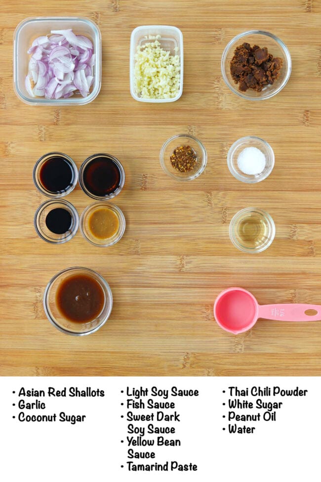 Labeled pad mee korat sauce ingredients on a wood board.