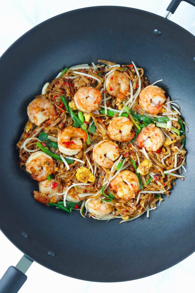 Pad Mee Korat with Shrimp in a wok.