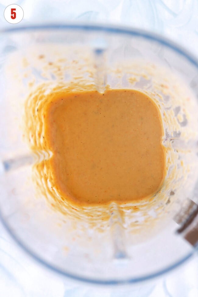 Blended white bean sauce with miso paste and chili oil in a blender jug.