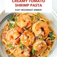 Plate with shrimp pasta with creamy cherry tomato sauce, spinach, basil topped with grated parmesan. Text overlay "Creamy Tomato Shrimp Pasta", "Easy Weeknight Dinner!", and "That Spicy Chick".