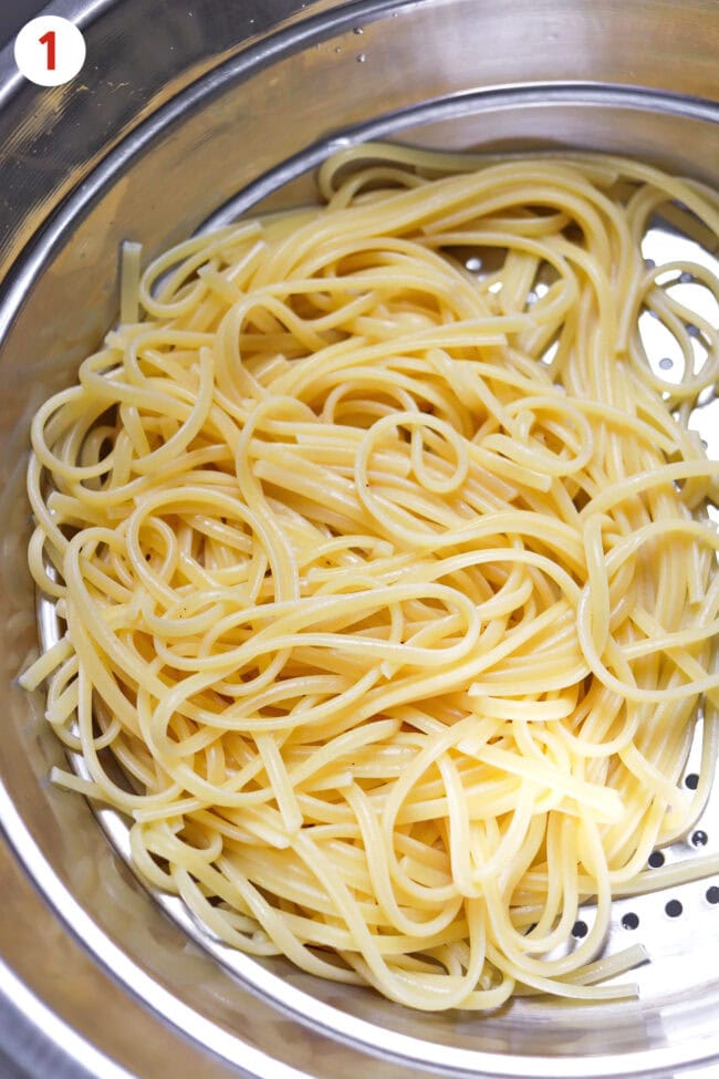 Cooked and drained linguini pasta in a colander.