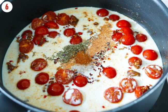 Milk and seasonings added to a pan with sautéed cherry tomatoes, garlic, and shallots.
