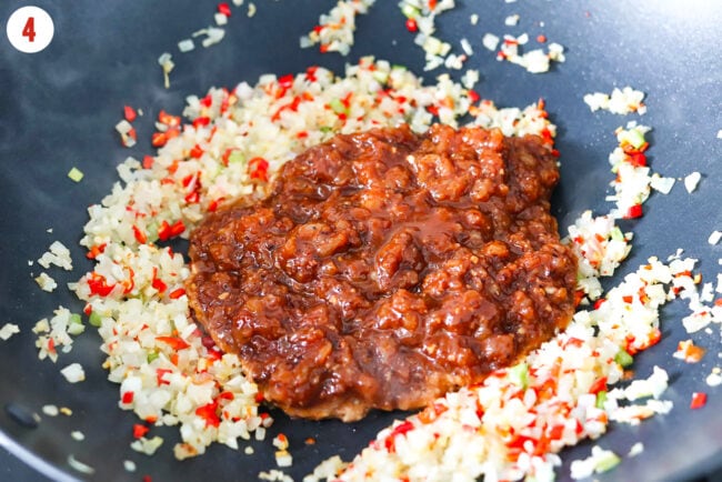 Marinated Korean ground chicken added to wok with stir-fried aromatics and onion.