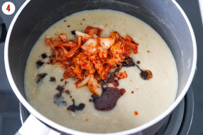 Pot with creamy savory oats, gochujang, soy sauce and kimchi.