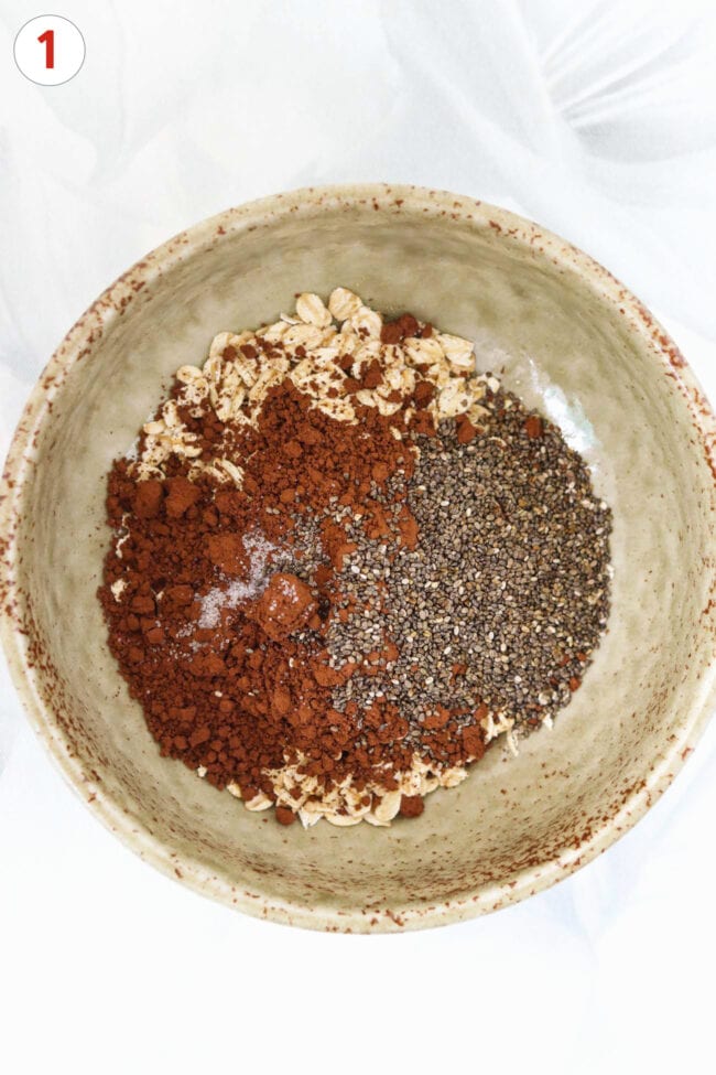 Oats, chia seeds, and dutch process cocoa powder in a bowl.