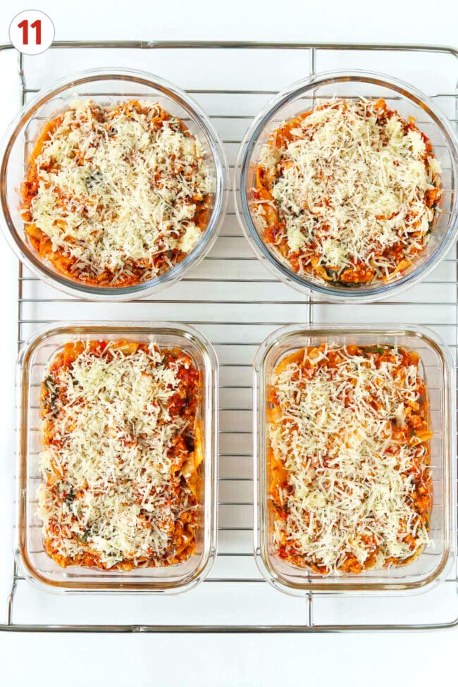 Tomato pesto lasagna topped with shredded mozzarella and parmesan in meal prep containers on a wire rack.