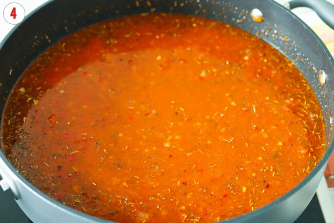 Red pesto tomato sauce with spices and seasonings in a pan.