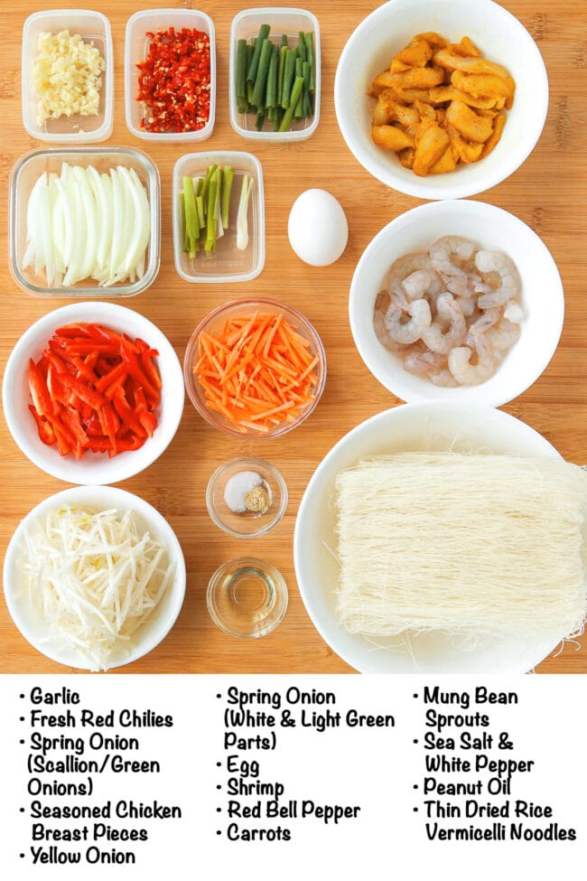 Labeled ingredients for Singapore Noodles with Chicken and Shrimp on a wood board.