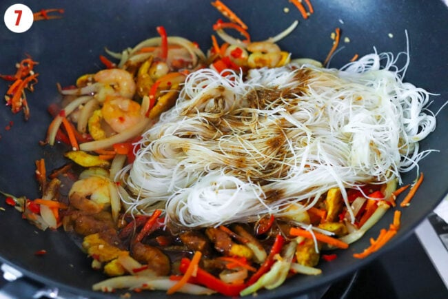 Rice vermicelli and stir-fry curry sauce added to wok with stir-fried vegtables, shrimp and chicken.