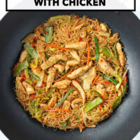 Pancit bihon noodles stir-fry with chicken and vegetables in wok. Text overlay "Filipino Pancit Bihon with Chicken" and "That Spicy Chick".
