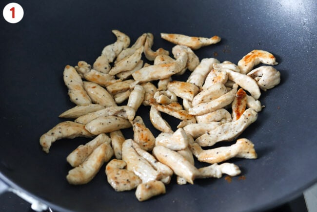 Cooked seasoned chicken pieces in a wok.