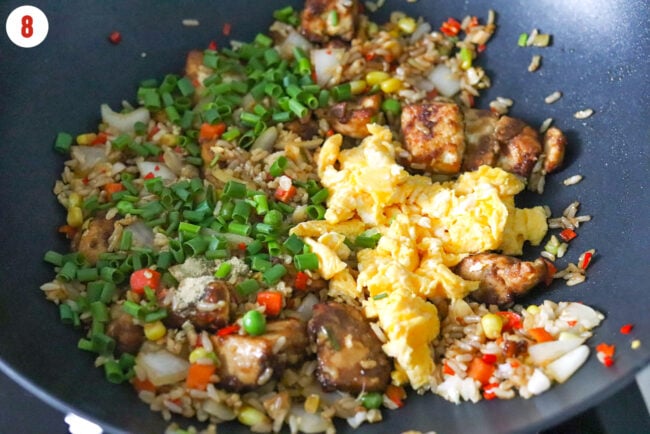 Scrambled eggs, green onions, white pepper and sea salt in a wok with tofu fried rice with vegetables.
