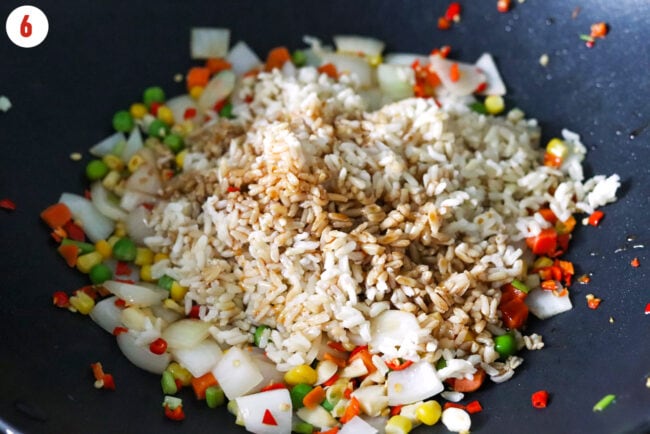 Cooked long grain brown rice and fried rice sauce added to wok with stir-fried vegetables.
