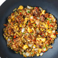 Air fryer tofu fried rice with vegetables and scrambled eggs in a wok.