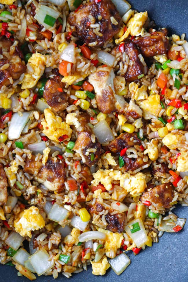 Closeup of air fryer tofu fried rice with vegetables and scrambled eggs in a wok.