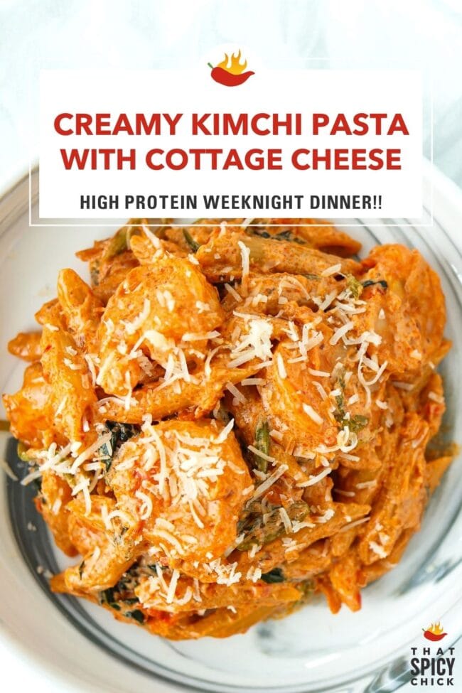 Closeup top view of plate with creamy kimchi pasta with shrimp topped with parmesan. Text overlay "Creamy Kimchi Pasta with Cottage Cheese", "High Protein Weeknight Dinner!!" and "That Spicy Chick".