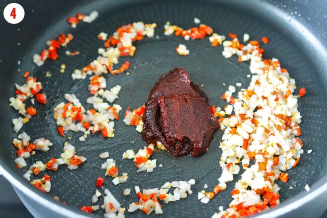 Gochujang in pan with sautéed minced garlic, shallots and red chilies.