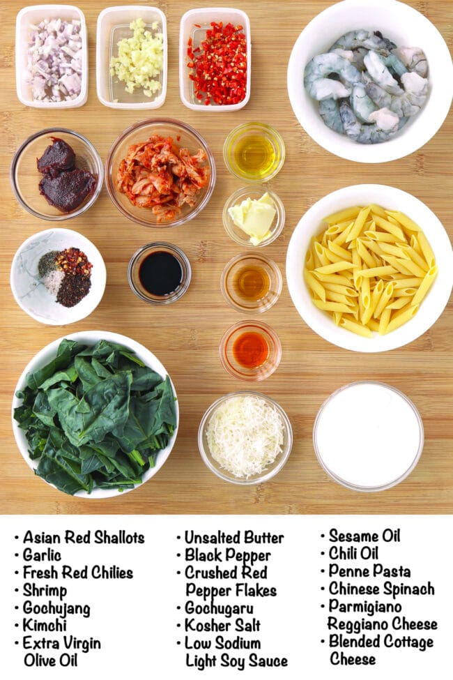 Labeled ingredients for Creamy Kimchi Pasta with Cottage Cheese on a wood board.