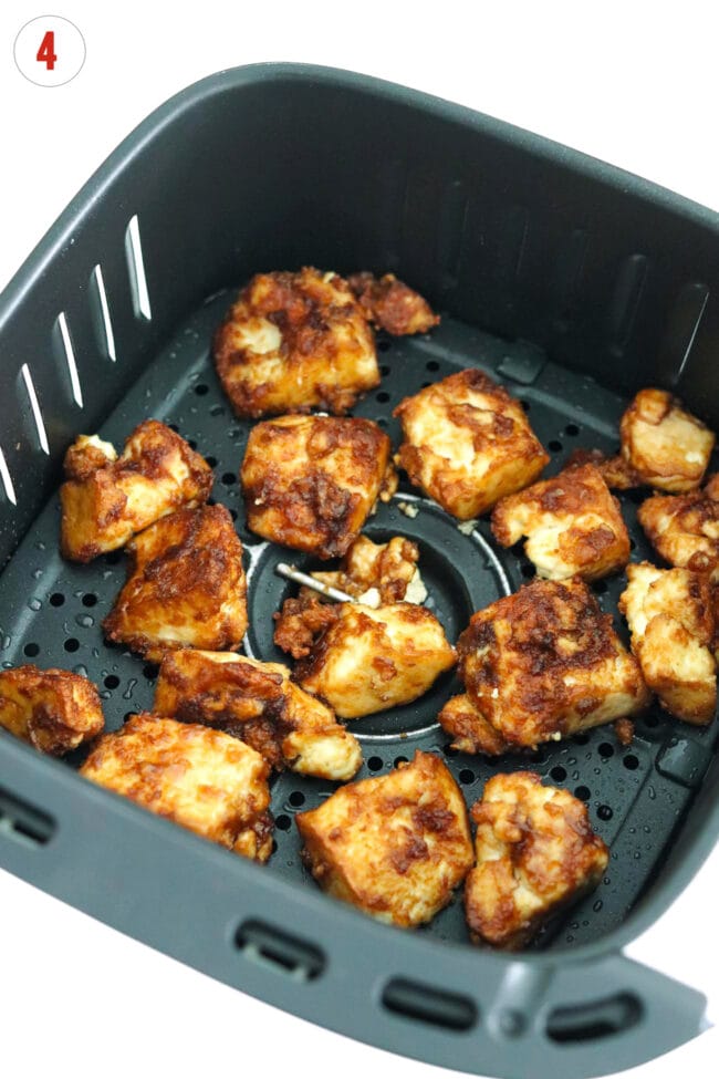 Crispy air fryer tofu chunks in air fryer basket.