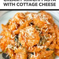 Front view of view of plate kimchi pasta with shrimp, spinach and grated parmesan. Text overlay "High Protein Dinner!", "Creamy Kimchi Pasta with Cottage Cheese" and "That Spicy Chick".