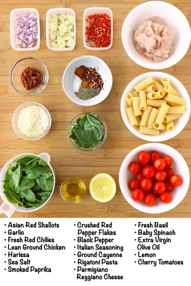 Labeled ingredients for Harissa Pasta with Cherry Tomatoes on a wood board.