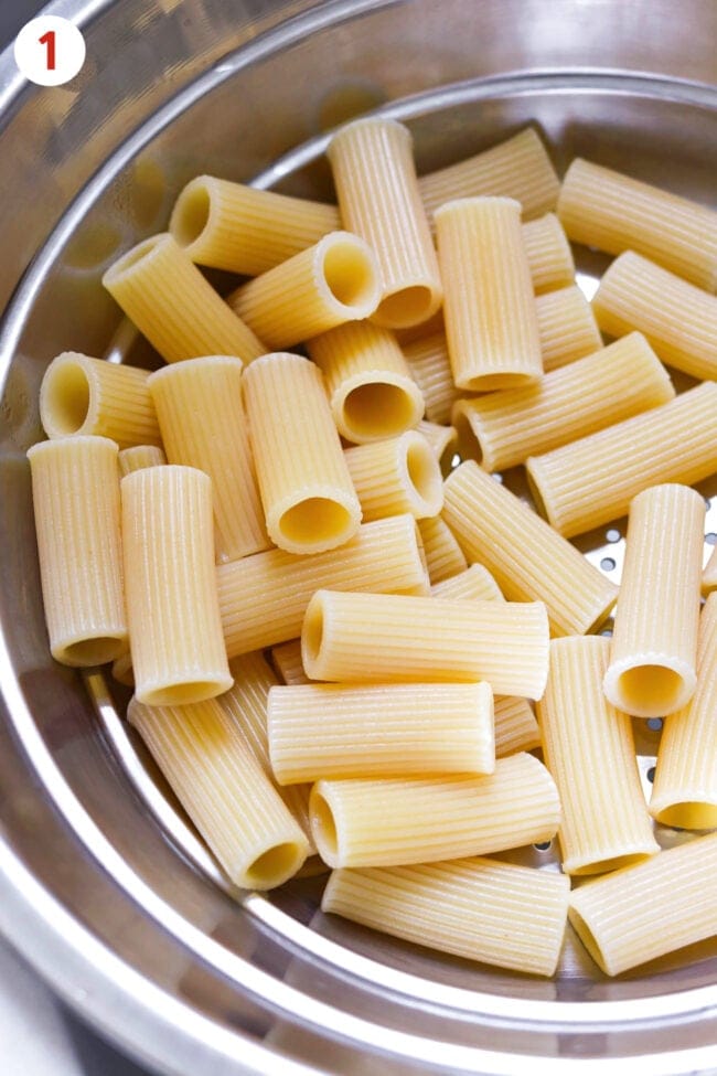 Cooked rigatoni pasta in a colander.
