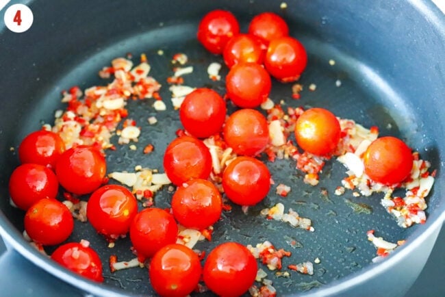 Cherry tomatoes in a pan with sautéed shallots, garlic and red chilies.