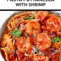 Closeup front view of plate with spicy tomato pasta with shrimp topped with grated cheese and basil leaves. Text overlay "Easy Weeknight Dinner!, "Pasta Puttanesca with Shrimp" and "That Spicy Chick".