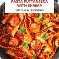 Pan with spicy tomato sauce pasta with shrimp topped with basil leaves. Text overlay "Pasta Puttanesca with Shrimp", "Spicy | Easy | Delicious!!" and "That Spicy Chick".