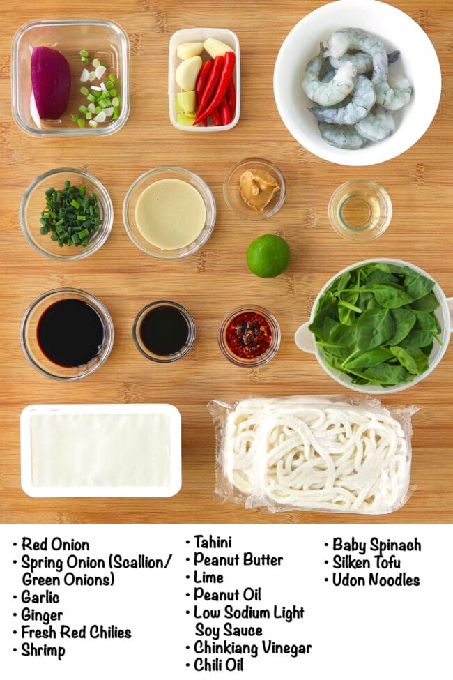 Labeled ingredients for Spicy Tahini Peanut Noodles on a wood board.