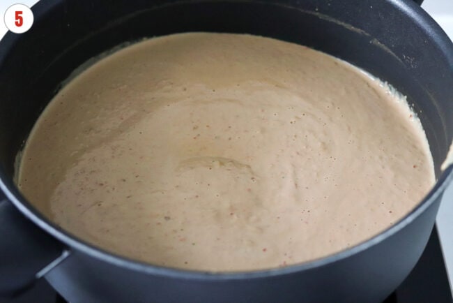 Blended silken tofu tahini peanut butter and chili oil sauce in a skillet.